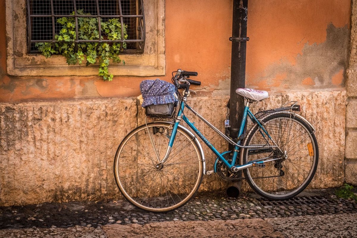 Una bicicletta appoggiata a un muro color ocra