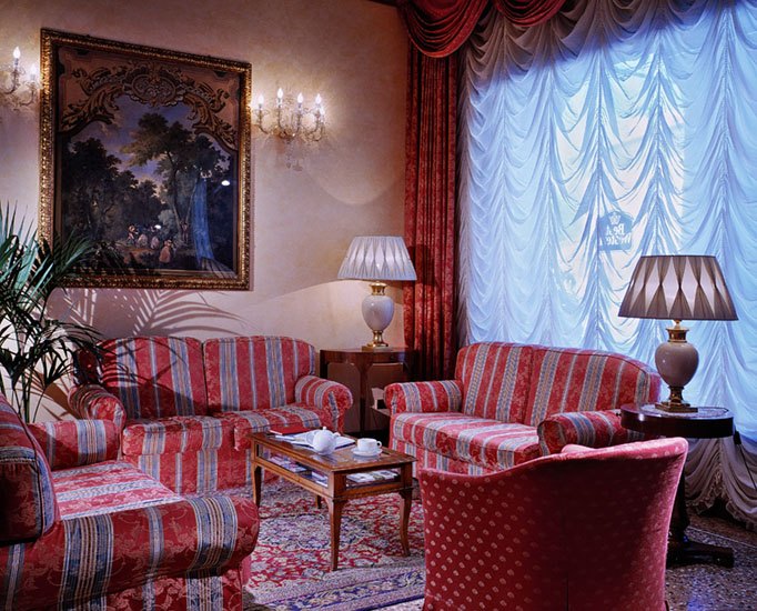 La hall dell’Albergo dei Medaglioni con divani rossi e una grande finestra