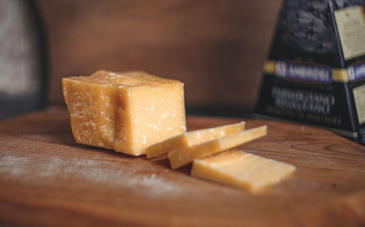 A wedge of Parmigiano Reggiano on a wooden board