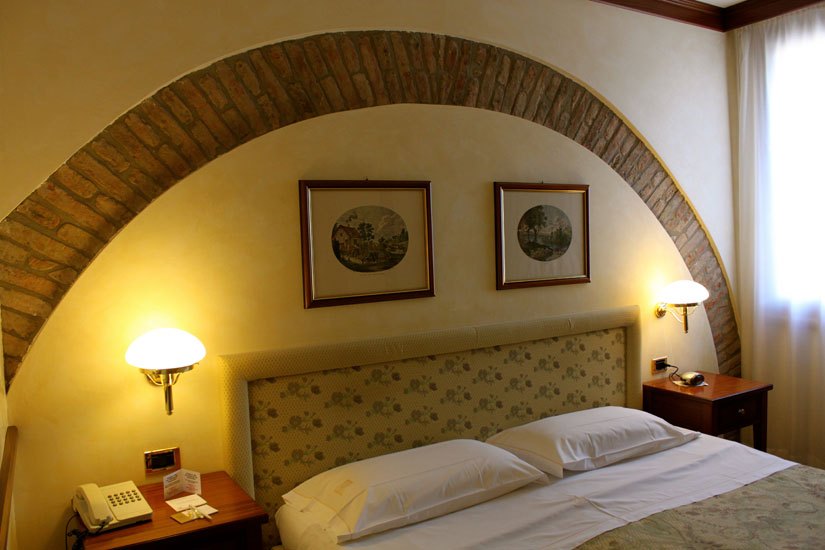 Camera matrimoniale sotto un arco in mattoni a vista